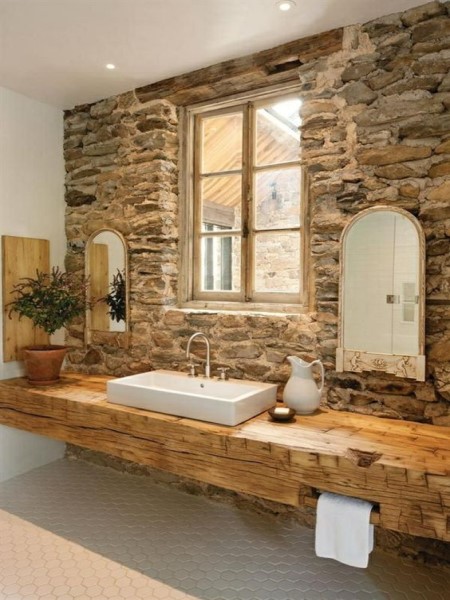 Baño rústico con pared de piedra